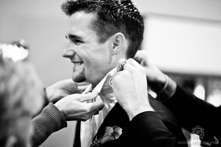 wedding coordinator and staff fix grooms collar