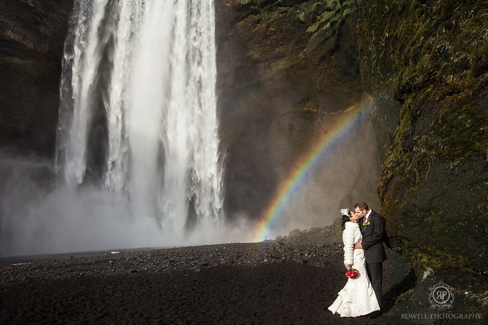 couple kissing at Skogafoss after their iceland wedding ceremony down the road at Seljalandsfoss.