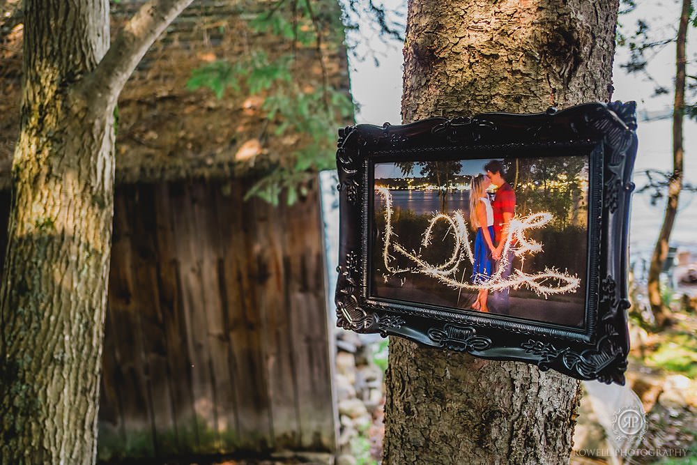 framed photos nailed to trees at wedding