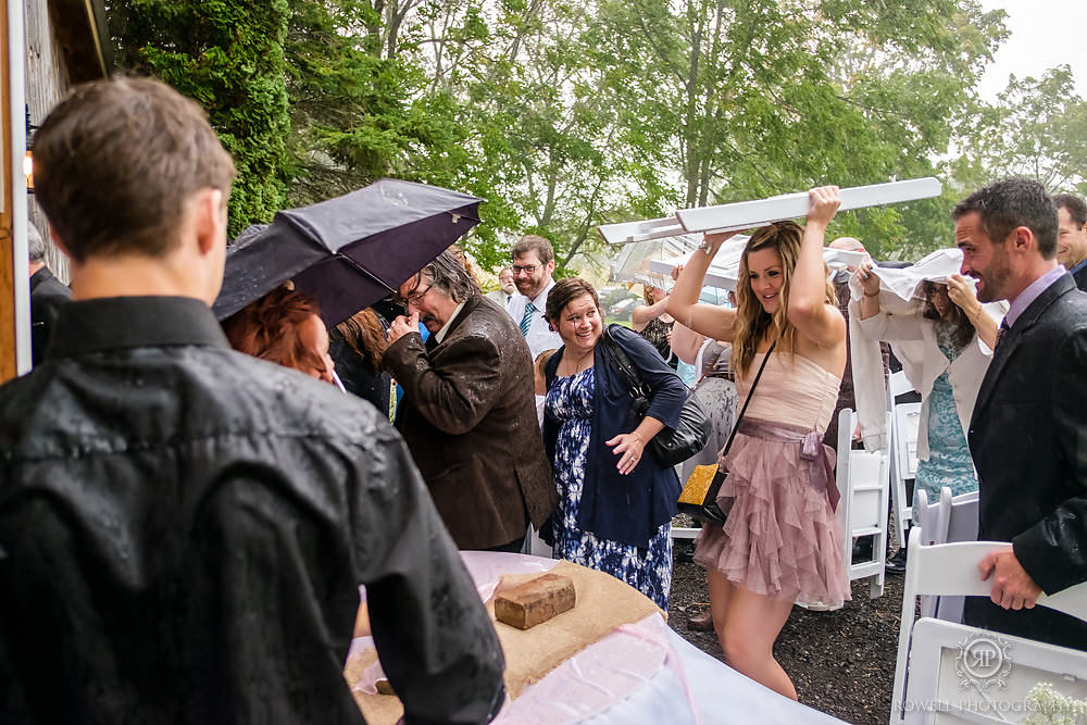 guests run for cover from rain canada wedding