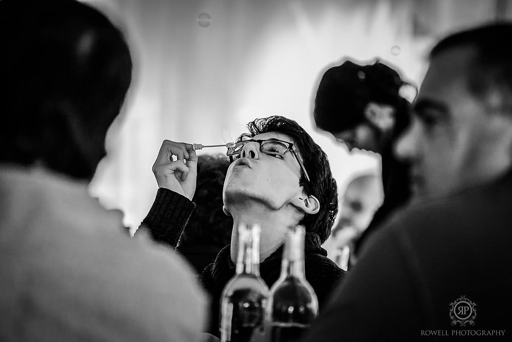 kid blowing bubbles at a wedding